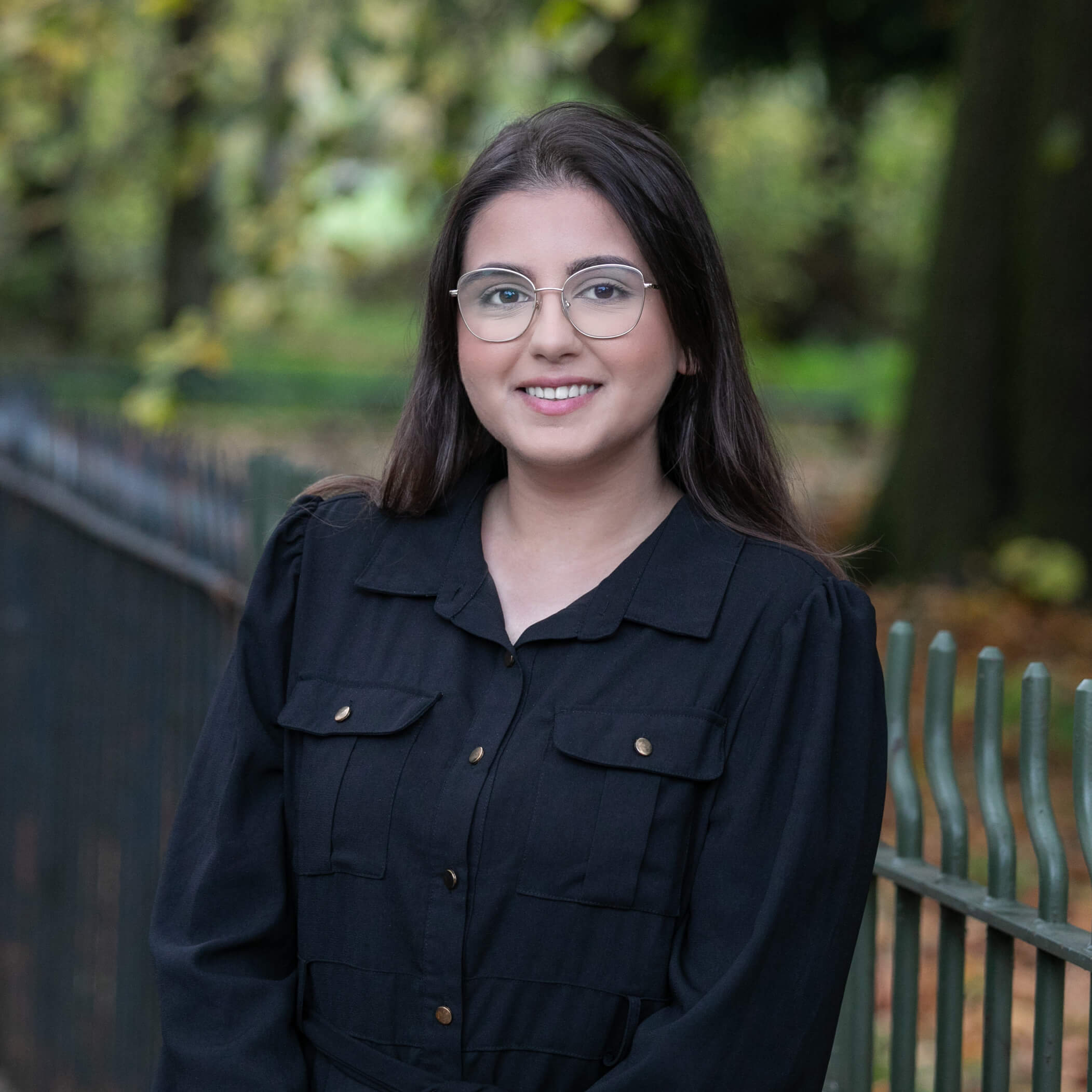 Laiba Malik, a smartly-dressed solicitor, standing in a vibrant park.