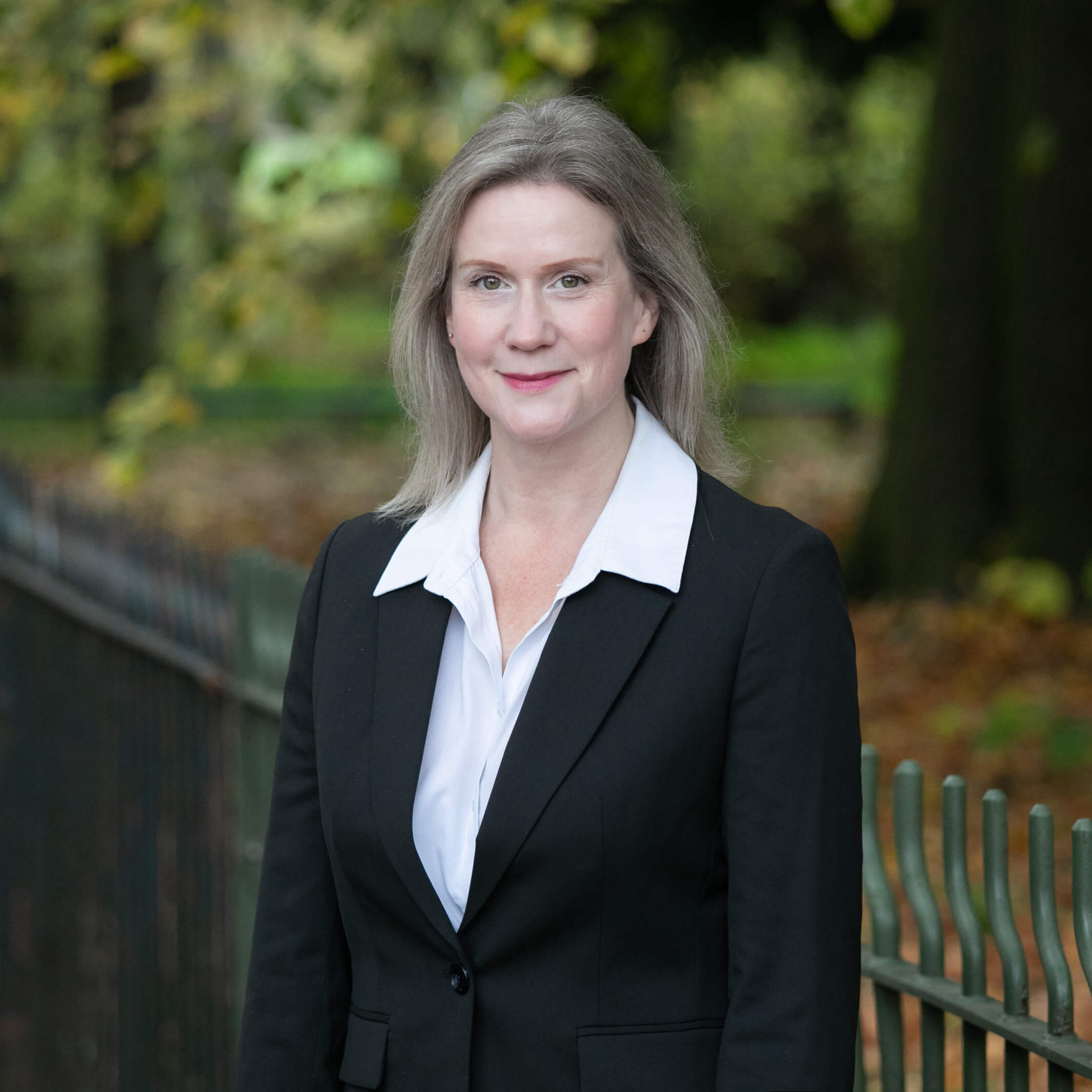 Marian Sexton-Jennings, a smartly-dressed solicitor, standing in a vibrant park.